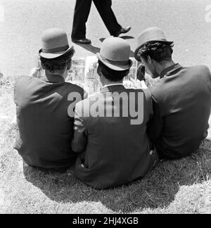 Derby Day at Epsom. Pictured, three lads from Newmarket sitting on the grass studying form. All wearing hats they describe as 'hard hitters' they are similar to bowlers but have a curved brim. 3rd June 1959. Stock Photo