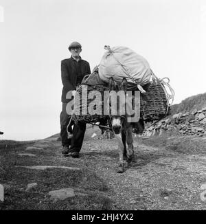 The last twenty three residents of Inishark Island (sometimes called Shark Island), off the coast of County Galway, Ireland, are pictured evacuating the Island. The residents have lost their battle with the winds. After being cut off from the mainland for weeks, sometimes months on end, the six families have left for the mainland to live in houses provided by the Irish government. 21st October 1960. Stock Photo