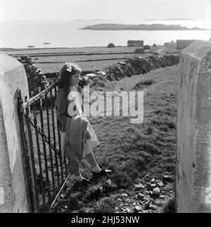 The last twenty three residents of Inishark Island (sometimes called Shark Island), off the coast of County Galway, Ireland, are pictured evacuating the Island. The residents have lost their battle with the winds. After being cut off from the mainland for weeks, sometimes months on end, the six families have left for the mainland to live in houses provided by the Irish government. 21st October 1960. Stock Photo