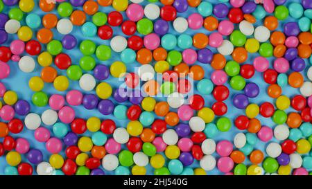 colorful sweet candy balls on blue pastel background. trendy color for wallpaper or background. Stock Photo