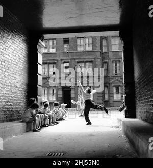 Inspired by the Wimbledon tennis championships taking place, these children enjoy a game of tennis in the back streets around their home in South East London.9th July 1961. Stock Photo
