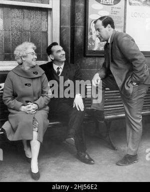 Mrs Elizabeth Charlton, mother of Manchester United and England star Bobby Charlton, pictured at a railway station with Jackie Milburn and Clement Freud (right). Circa 1957. Stock Photo