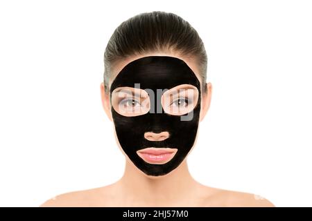 Black charcoal mask facial treatment Asian beauty woman. Wellness and spa purifying peel off mask face portrait, isolated on white background Stock Photo