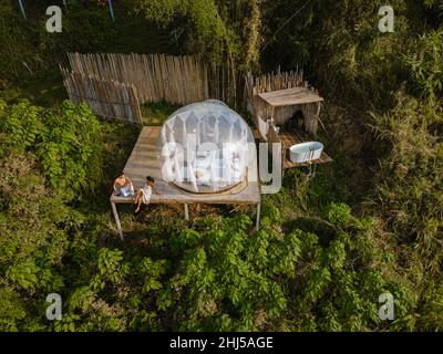 Bubble dome tent glamping in the mountains of Chiang Mai Thailand, Transparent bell tent with comfortable bed and pillow in the forest, glamping hotel, luxury travel, glamourous camping.  Stock Photo