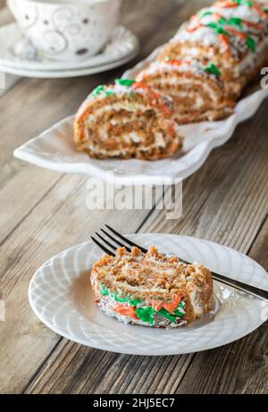 An Easter decorated jelly roll carrot cake on a platter with a serving in front. Stock Photo