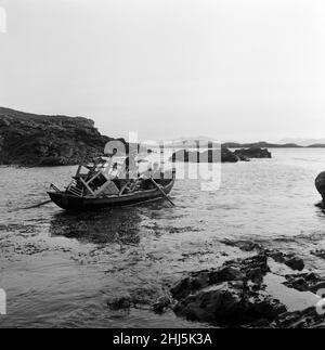 The last twenty three residents of Inishark Island (sometimes called Shark Island), off the coast of County Galway, Ireland, are pictured evacuating the Island. The residents have lost their battle with the winds. After being cut off from the mainland for weeks, sometimes months on end, the six families have left for the mainland to live in houses provided by the Irish government. 21st October 1960. Stock Photo