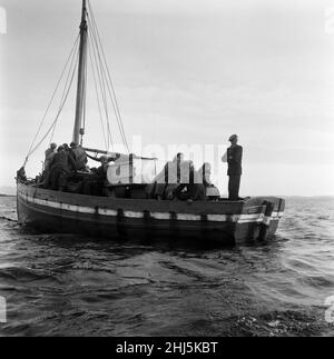 The last twenty three residents of Inishark Island (sometimes called Shark Island), off the coast of County Galway, Ireland, are pictured evacuating the Island. The residents have lost their battle with the winds. After being cut off from the mainland for weeks, sometimes months on end, the six families have left for the mainland to live in houses provided by the Irish government. 21st October 1960. Stock Photo