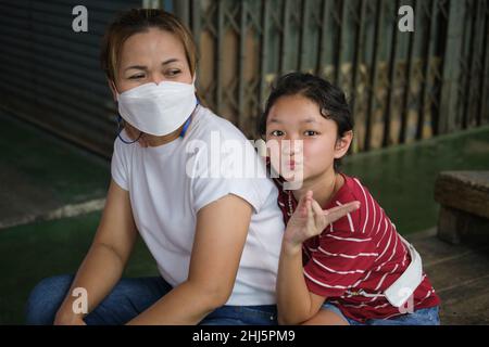A Thai mother and her daughter posing in a market in Bangkok, Thailand Stock Photo