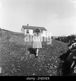 The last twenty three residents of Inishark Island (sometimes called Shark Island), off the coast of County Galway, Ireland, are pictured evacuating the Island. The residents have lost their battle with the winds. After being cut off from the mainland for weeks, sometimes months on end, the six families have left for the mainland to live in houses provided by the Irish government. 21st October 1960. Stock Photo