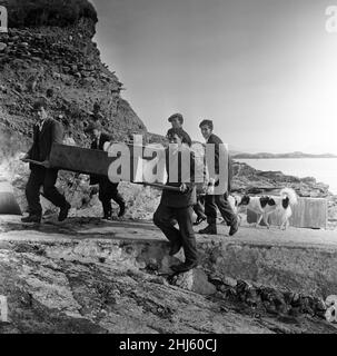 The last twenty three residents of Inishark Island (sometimes called Shark Island), off the coast of County Galway, Ireland, are pictured evacuating the Island. The residents have lost their battle with the winds. After being cut off from the mainland for weeks, sometimes months on end, the six families have left for the mainland to live in houses provided by the Irish government. 21st October 1960. Stock Photo