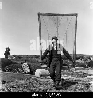 The last twenty three residents of Inishark Island (sometimes called Shark Island), off the coast of County Galway, Ireland, are pictured evacuating the Island. The residents have lost their battle with the winds. After being cut off from the mainland for weeks, sometimes months on end, the six families have left for the mainland to live in houses provided by the Irish government. 21st October 1960. Stock Photo