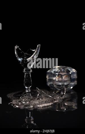 Broken wine glass and spilled wine on black background Stock Photo