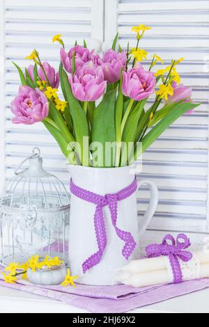 bouquet of pink tulips and winter jasmine in vintage vase Stock Photo