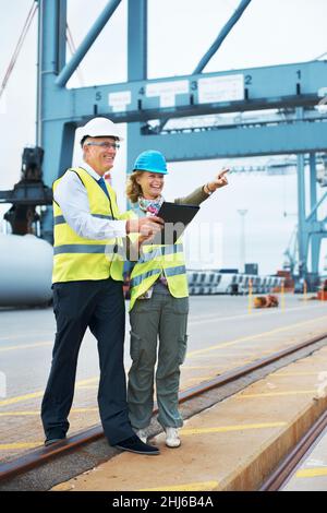 Laughter makes any job easier. Two engineers discussing planning on a site while looking away. Stock Photo