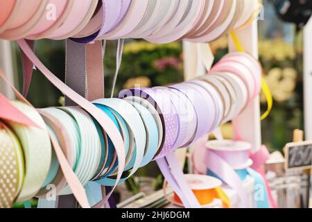 gift wrapping ribbons on a counter in a flower shop. various colors of ribbons for presents. gifts for holidays. small business Stock Photo