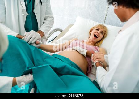 Woman hardly pushing to give child birth, natural labor and delivery Stock Photo