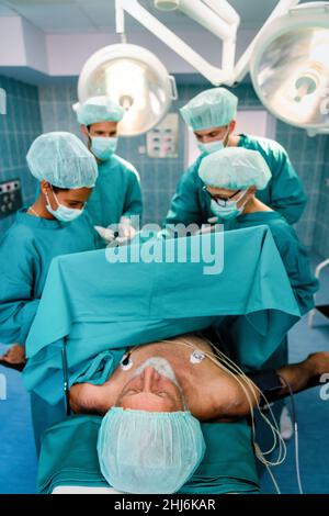 Exhausted surgeons at the emergency room as a sign of stress and overwork Stock Photo