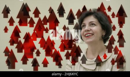 Successful confidence middle aged  business woman looking up positive daydreaming laughing in business card with red up arrows. Stock Photo