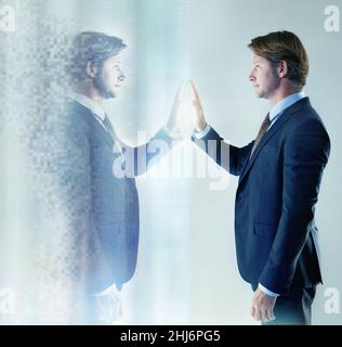 Discover who you are. Cropped shot of a businessman reaching out to touch a computer generated image of himself. Stock Photo