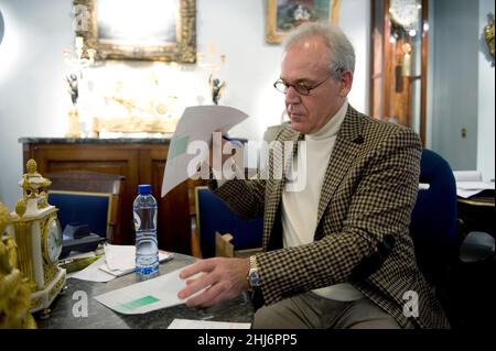 Amsterdam, Netherlands. Antique Clock's Store owner writing invoices for a fresh customer after they bought  a 350 year old clock and hour work. Stock Photo