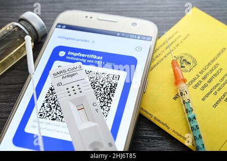 Digitales Impfzertifikat auf Smartphone mit negativem Corona-Schnelltest, Impfausweis und Impfspritze, Symbolfoto digitaler Impfnachweis und 2G+-Regel Stock Photo