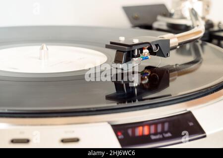 closeup of vinyl turntable, hi-fi headshell cartridge in action, playing analog lp plate with music, place for text. Stock Photo