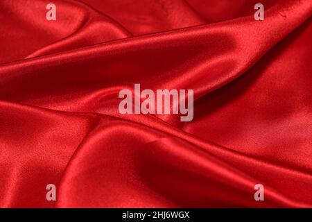 Texture of crumpled red satin fabric, beautiful pattern. Stock Photo