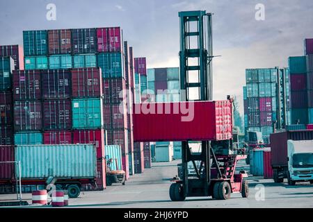 Container stacks and trucks and container forklifts Industry and Transportation Perspectives trade and investment Stock Photo