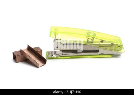 Close up of transparent neon green stapler next to bronze refill staples on white background Stock Photo