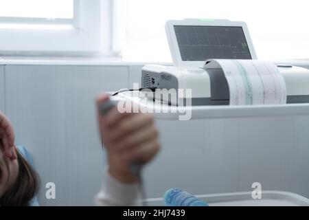 Close Up Pregnant Woman On Hospital Couch During Medical Control Cardiotocography. Visit Gynecologist Doctor At Clinic For Pregnancy Consultant Stock Photo