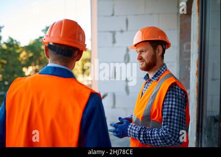 Two builder standing talking at construction site Stock Photo