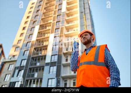 Builder worker using walkie-talkie on construction site Stock Photo