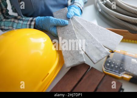 Builder holding gray tiles for bathroom in workshop closeup Stock Photo