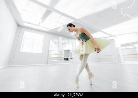 full length view of brunette ballerina rehearsing in studio Stock Photo