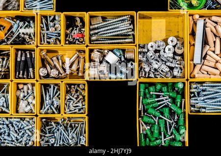Yellow case with small construction objects. Many storage compartments filled with builders accessories Stock Photo