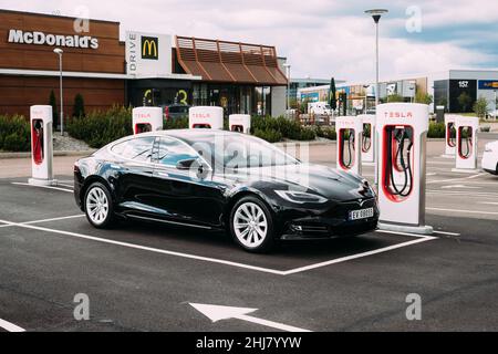 Black Color Tesla Model S 100d Car Parked At Charging Station. The Tesla Model S Is A Full-sized All-electric Five-door, Luxury Liftback, Produced By Stock Photo