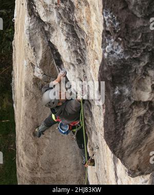 Candid shot of fit dark skinned male rock climber trying hard Stock Photo
