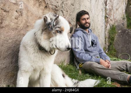 Hispanic man and brown border collie love each other outdoors Stock Photo