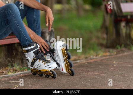 Close-up of young man putting on inline skates Stock Photo