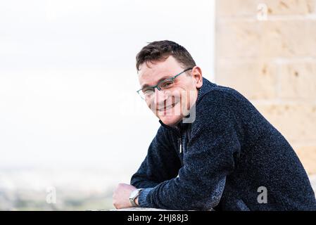 Portrait of a 42 year old white man confident and relaxed standing with a yellow and brown background Stock Photo