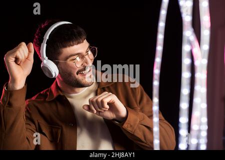man in headphones over neon lights of night club Stock Photo