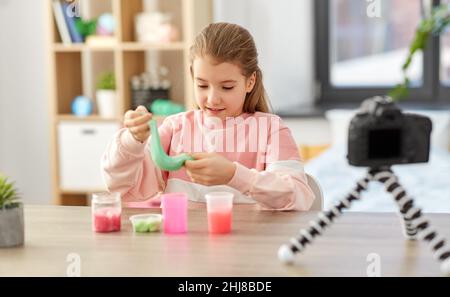 girl with slime and camera video blogging at home Stock Photo