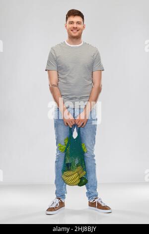 happy man with food in reusable net tote Stock Photo