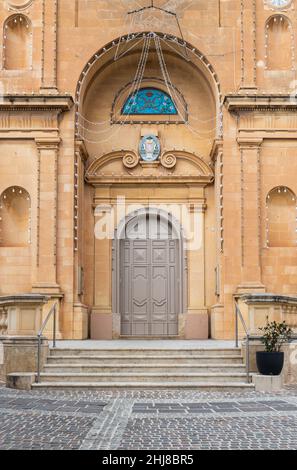 Marsaxlokk, Malta - 01 07 2022: Facade with an arched entrancer door of the cathedral Stock Photo