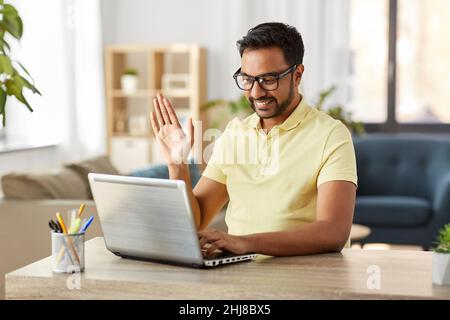 happy man with laptop having video chat at home Stock Photo