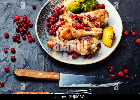 Delicious chicken legs fried with broccoli and cranberries. Stock Photo