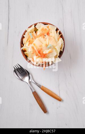 Overhead view of clay bowl with homemade pickled cabbage Stock Photo