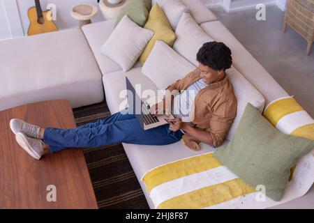 High angle view of african american young man using credit card while online shopping on laptop. unaltered, lifestyle, leisure activity, technology, o Stock Photo