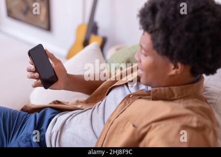 Smiling african american young man using smart phone with blank space, copy space. unaltered, lifestyle, leisure activity, wireless technology, social Stock Photo