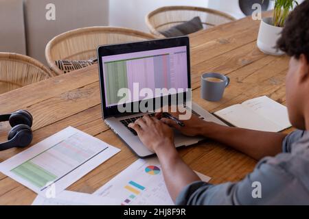 High angle view of african american young businessman using laptop while working at home. unaltered, business, wireless technology, typing, data, drin Stock Photo